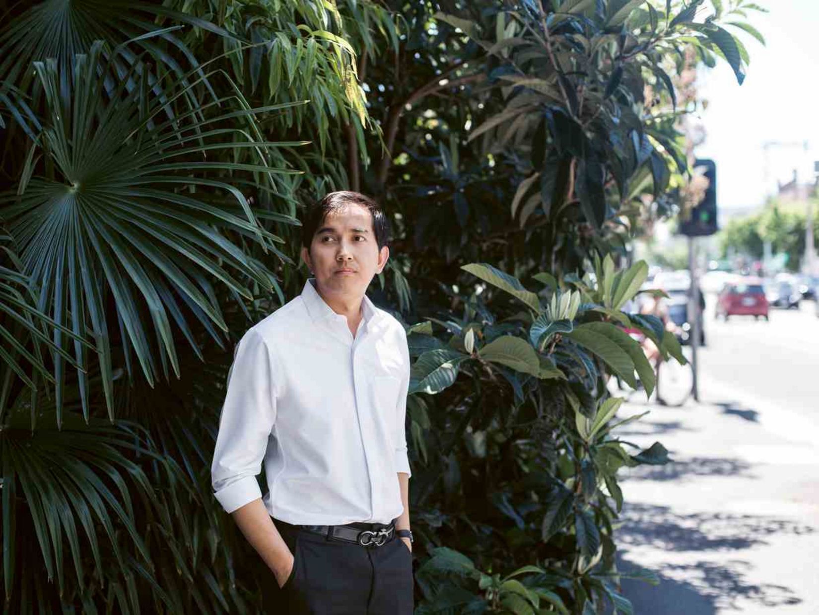 Dr. Sovann Kanitha at a street corner in front of a palm tree